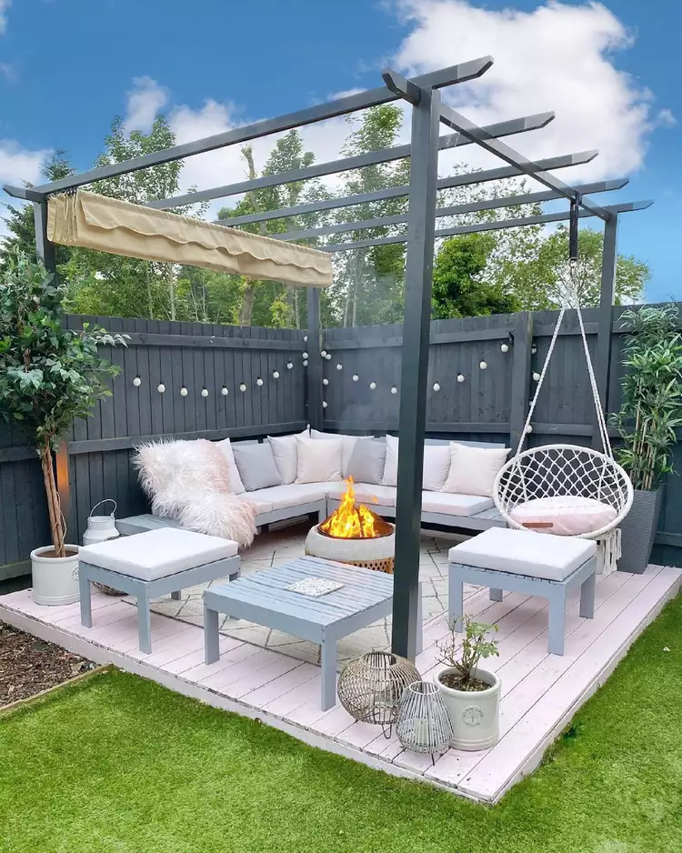 Beautiful outdoor patio with blue outdoor couch and hanging chair.