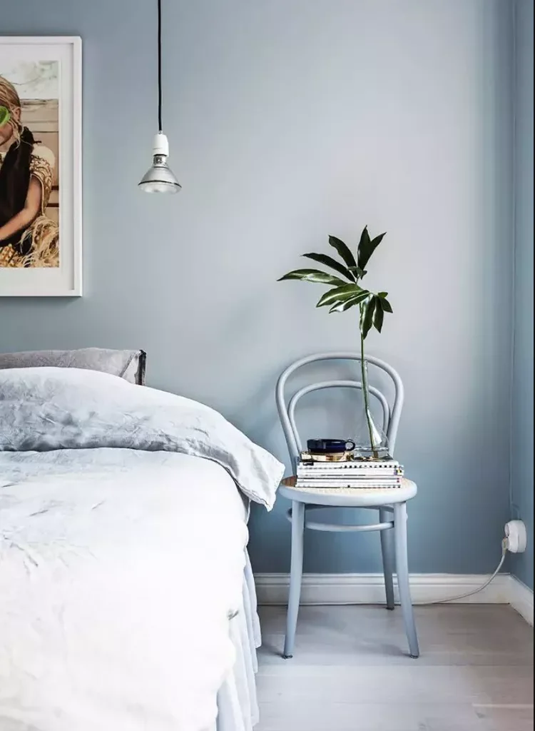Blue bedroom with hanging, exposed light bulb