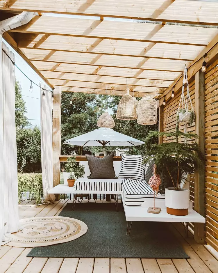 Outdoor wooden pergola with floating sofa underneath.