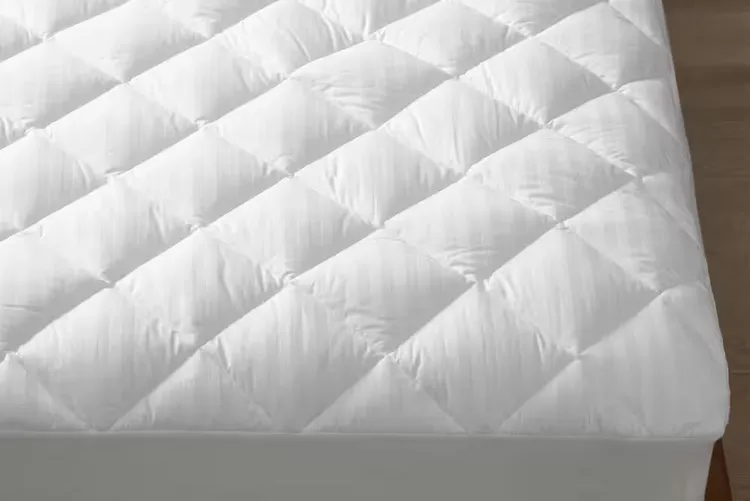 The Company Store Legends Hotel mattress pad on a made bed