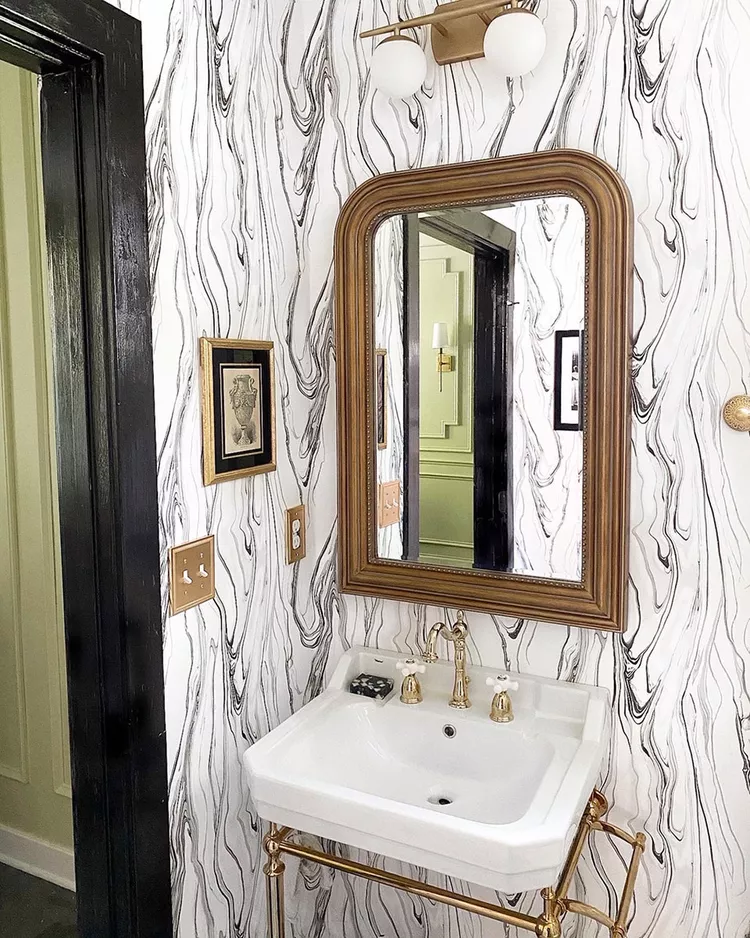 Retro bathroom with groovy wallpaper, brass sink framework, and sconce - Brexton Cole Interiors