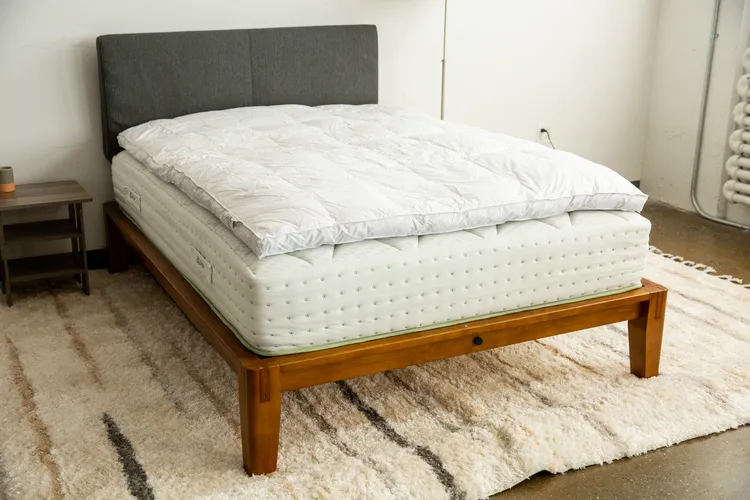 Parachute down alternative mattress pad on a bed beside a nightstand